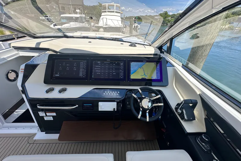  Yacht Photos Pics 2024 Cruisers Yachts 50 GLS helm with advanced navigation displays and sleek steering wheel.