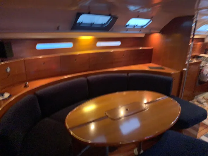 Ayla Yacht Photos Pics Interior of 1991 Beneteau First yacht with wooden table and blue seating.