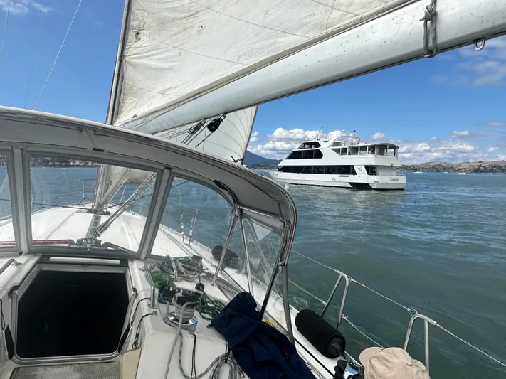 Ayla Yacht Photos Pics Sailing on a 1991 Beneteau First yacht with a ferry in the background.
