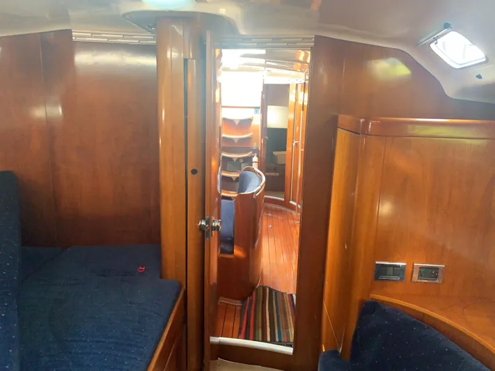 Ayla Yacht Photos Pics Interior of 1991 Beneteau First sailboat with wooden finish and blue seating.