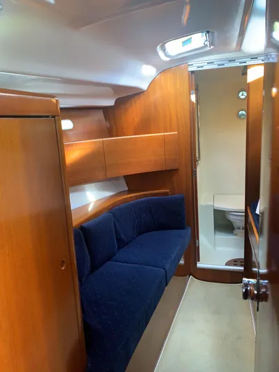 Ayla Yacht Photos Pics Interior of 1991 Beneteau First sailboat with wooden finish and blue seating.