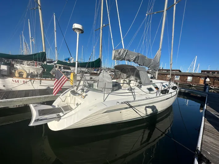 Ayla Yacht Photos Pics 1991 Beneteau First sailboat docked in marina, clear sky, American flag displayed.