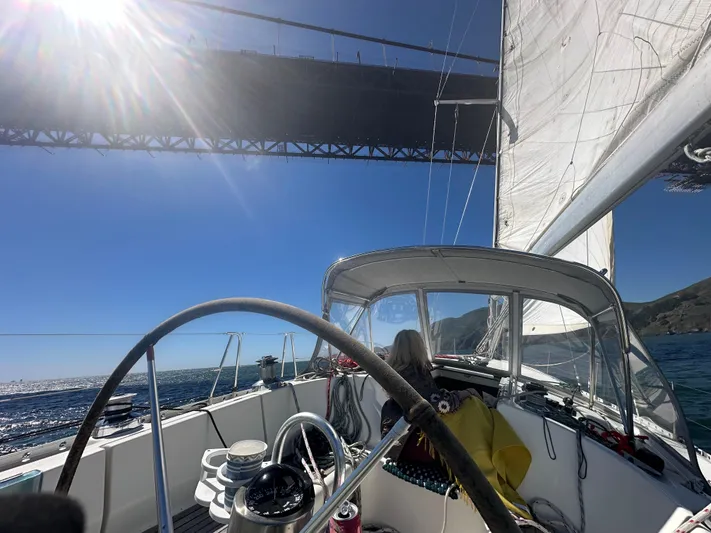 Ayla Yacht Photos Pics Sailing under a bridge on a 1991 Beneteau First yacht, sunny day, clear skies.