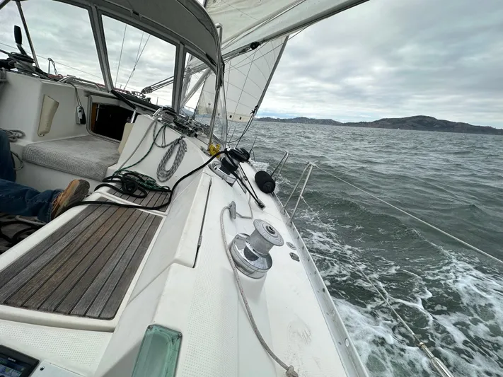 Ayla Yacht Photos Pics Sailing on a 1991 Beneteau First yacht in open waters under cloudy skies.