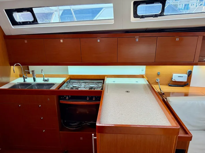 Sol Searcher Yacht Photos Pics Interior of 2013 Beneteau Oceanis 41 yacht kitchen with wood cabinetry and modern appliances.