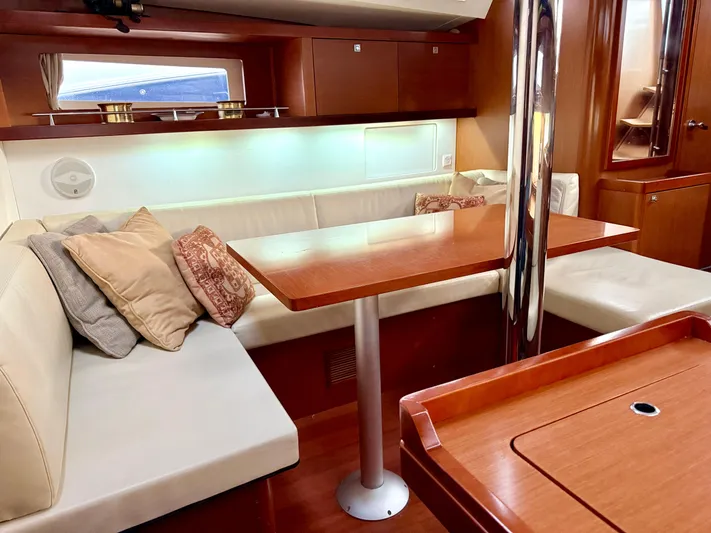 Sol Searcher Yacht Photos Pics Interior of 2013 Beneteau Oceanis 41 yacht with cozy seating and wooden table.