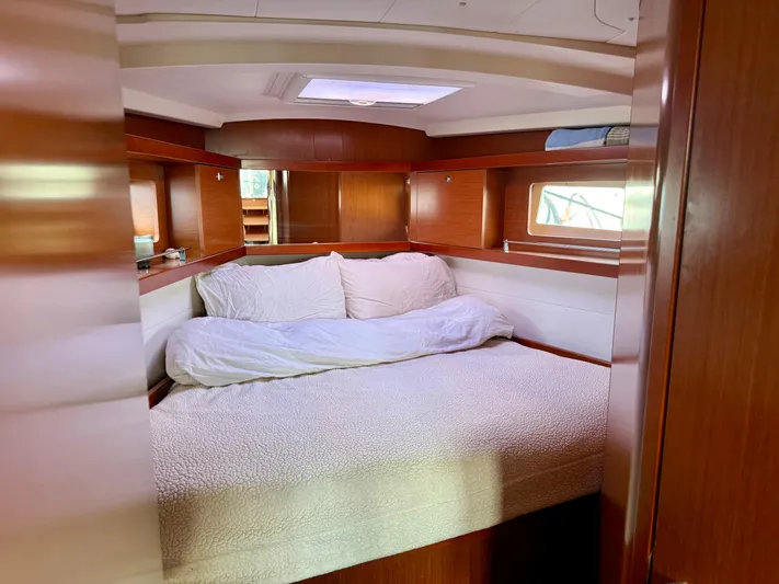 Sol Searcher Yacht Photos Pics Cozy cabin interior of 2013 Beneteau Oceanis 41 sailboat with wooden finish and comfortable bedding.