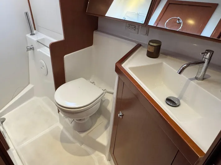 Sol Searcher Yacht Photos Pics 2013 Beneteau Oceanis 41 yacht bathroom with toilet, sink, and wooden cabinetry.