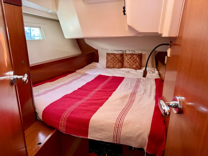 Sol Searcher Yacht Photos Pics Cozy cabin interior of 2013 Beneteau Oceanis 41 with red and white bedding.