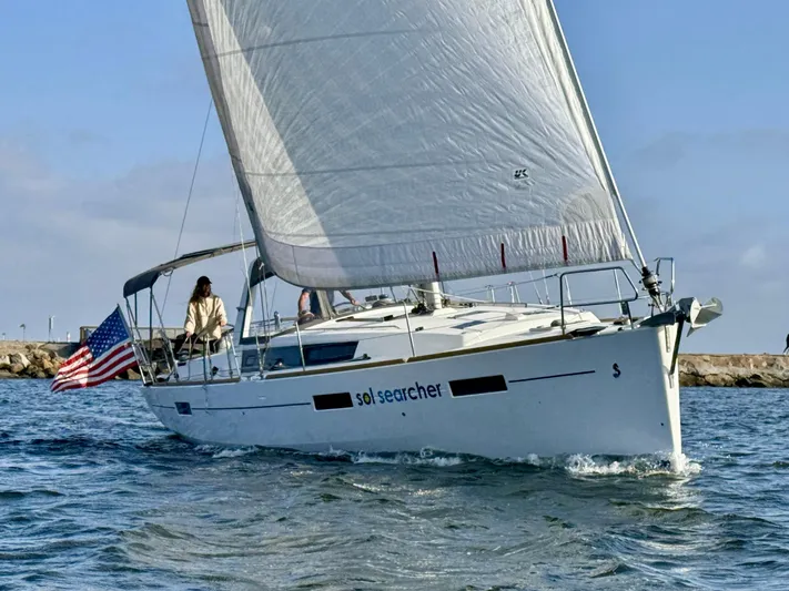 Sol Searcher Yacht Photos Pics Sailing yacht Beneteau Oceanis 41, 2013 model, cruising on open water with American flag.
