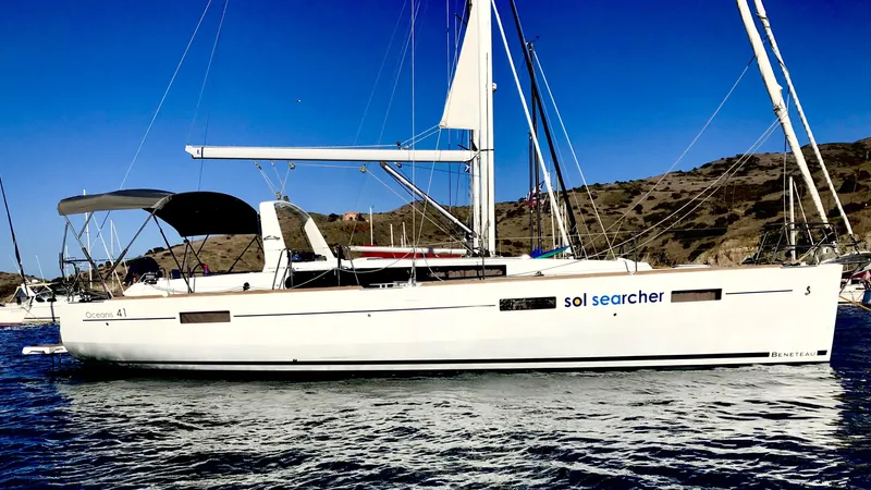 Sol Searcher Yacht Photos Pics 2013 Beneteau Oceanis 41 sailboat on water, clear sky, hillside background.
