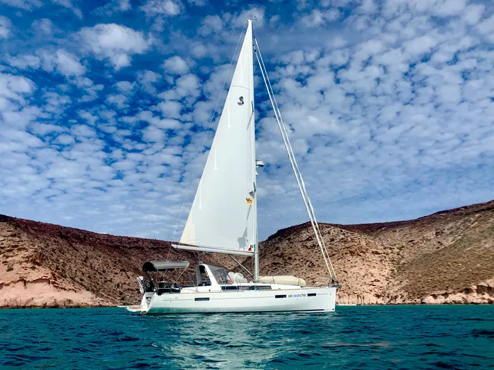 Sol Searcher Yacht Photos Pics 2013 Beneteau Oceanis 41 sailboat on turquoise water, under a partly cloudy sky.