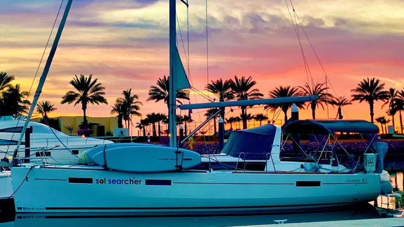 Sol Searcher Yacht Photos Pics Beneteau Oceanis 41 sailboat docked at sunset with palm trees in the background.