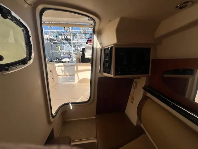  Yacht Photos Pics Interior view of 2013 Grady-White Freedom 335 boat cabin with seating and window.