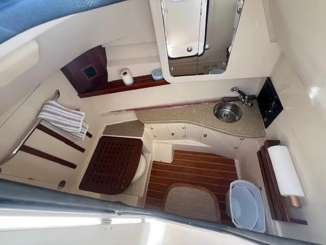  Yacht Photos Pics 2013 Grady-White Freedom 335 boat bathroom with sink, toilet, and wooden accents.