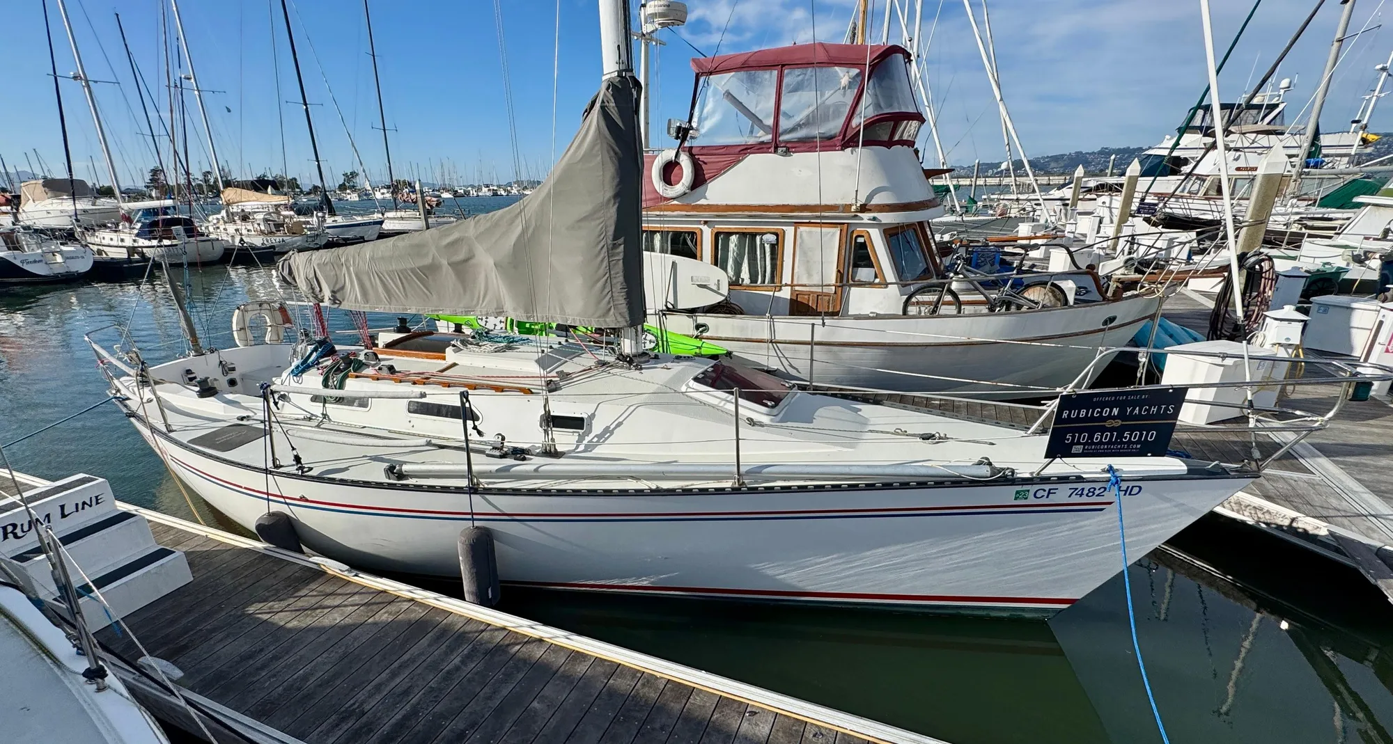 1984 Schock NY 36 sailboat docked in a marina, surrounded by other boats.