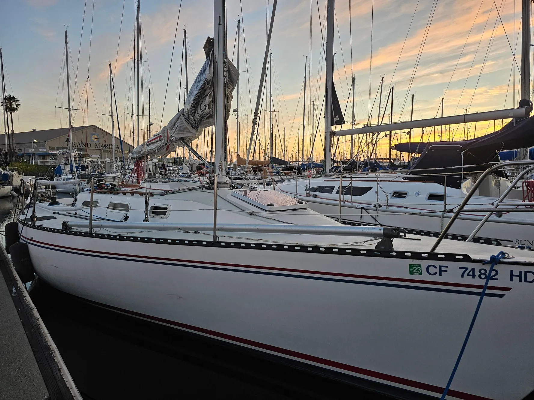 1984 Schock NY 36 sailboat docked at sunset, surrounded by other boats.