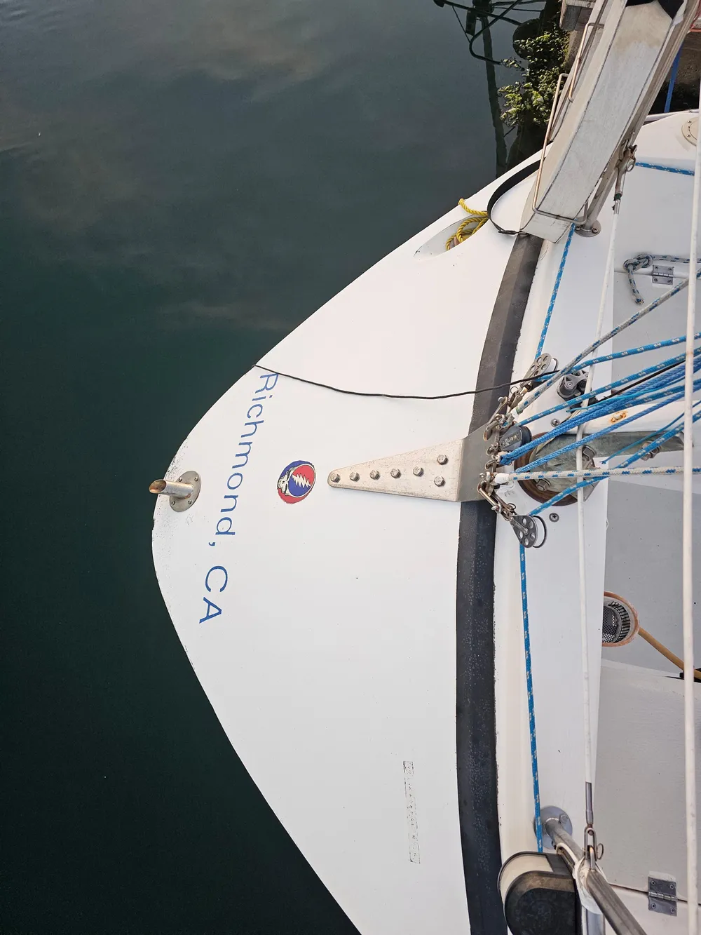 Sailboat stern with "Richmond, CA" text, Schock NY 36, 1984 model, docked in calm water.