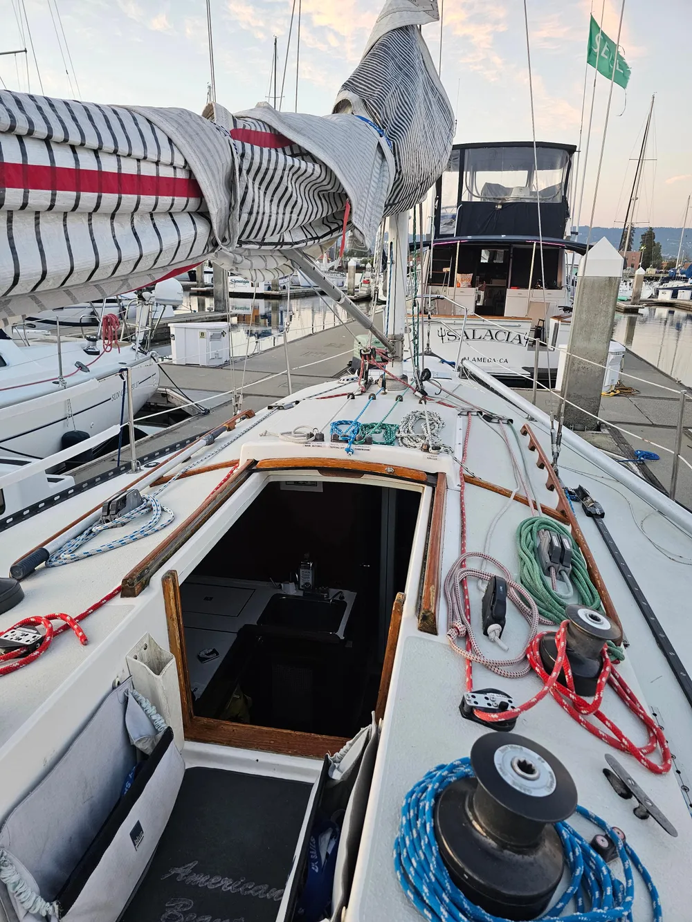 1984 Schock NY 36 sailboat deck with rigging and open cabin at marina.