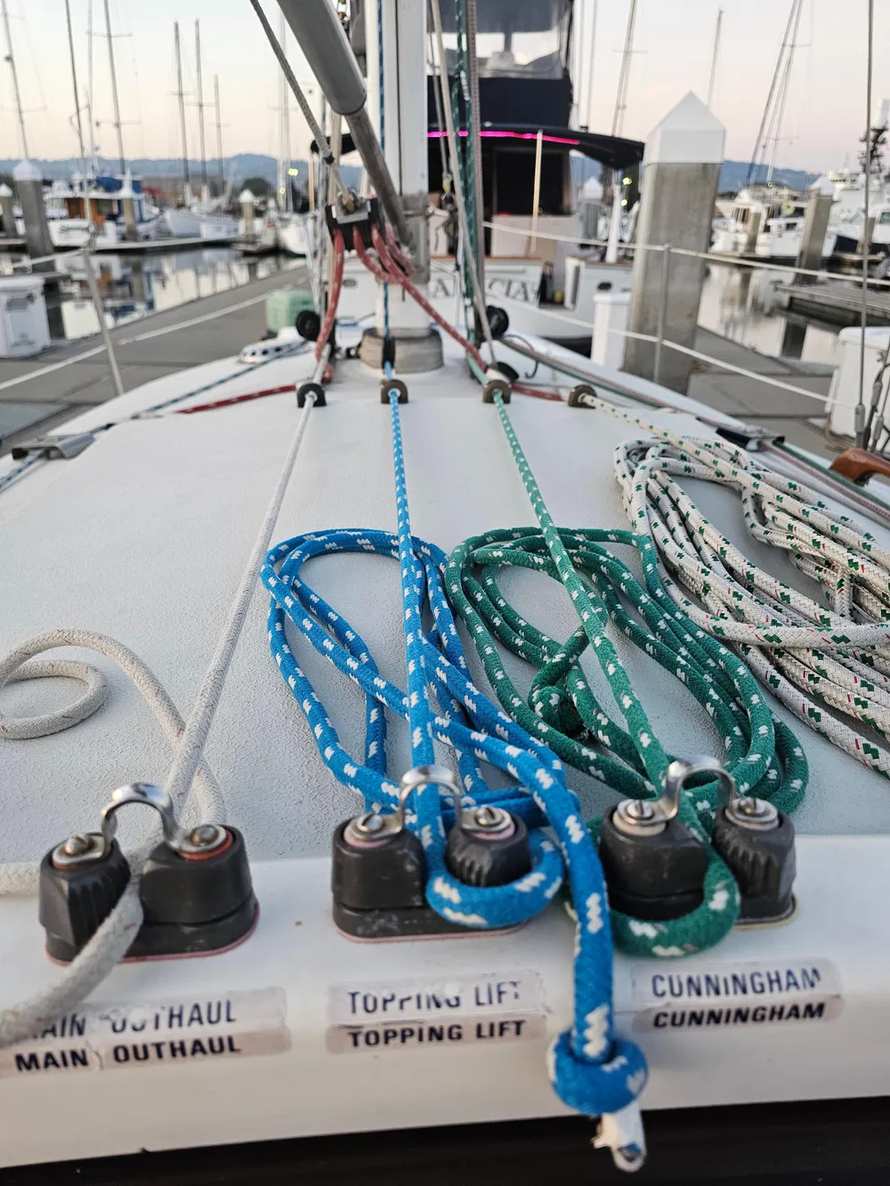 Sailboat deck with colorful ropes, Schock NY 36, 1984, docked at marina.