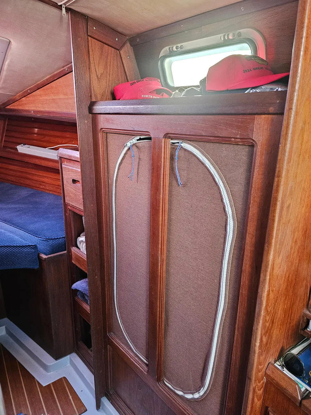 Interior of 1984 Schock NY 36 sailboat with wooden cabinetry and cozy sleeping area.
