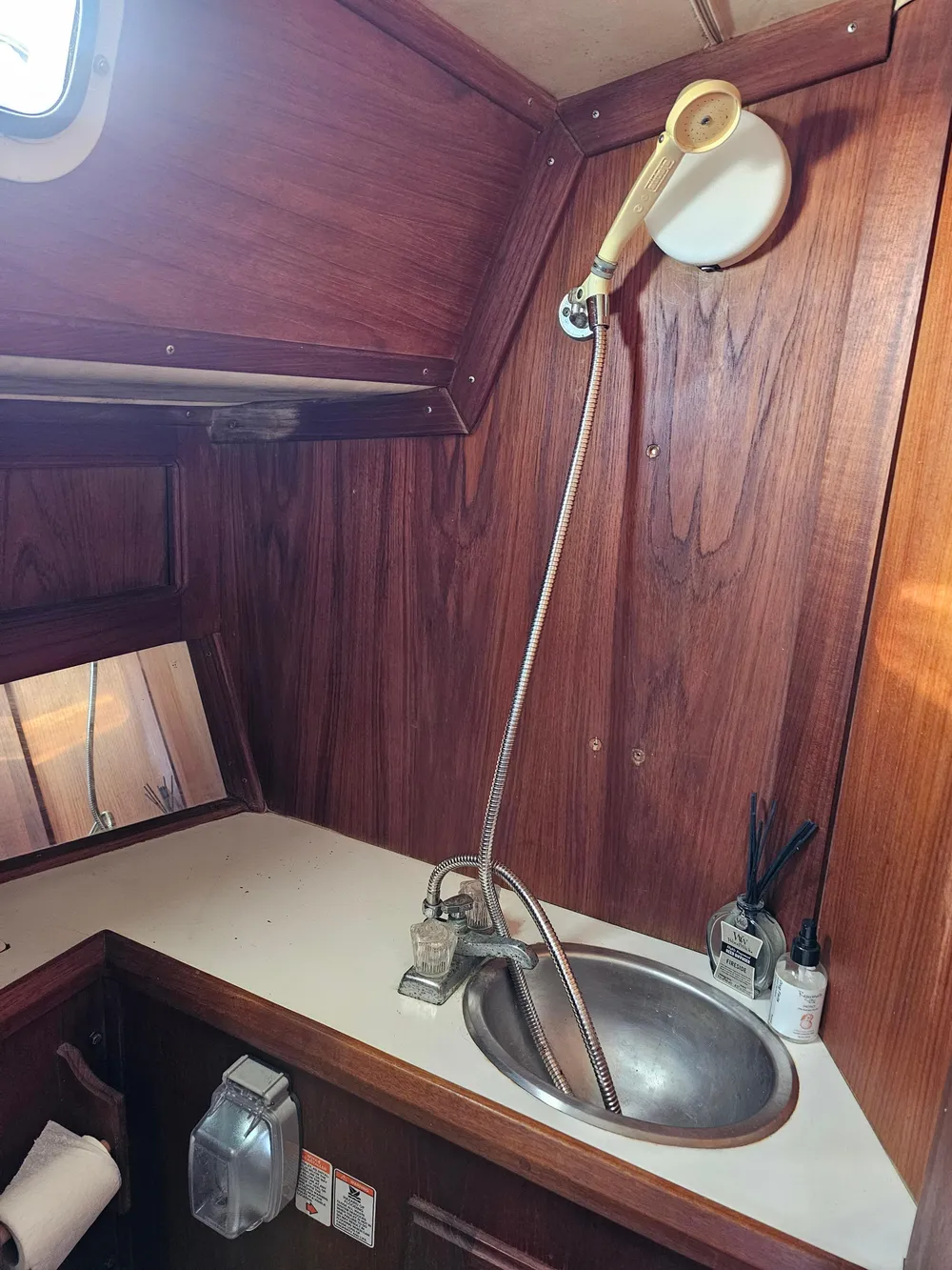 1984 Schock NY 36 yacht bathroom with wooden interior and stainless steel sink.