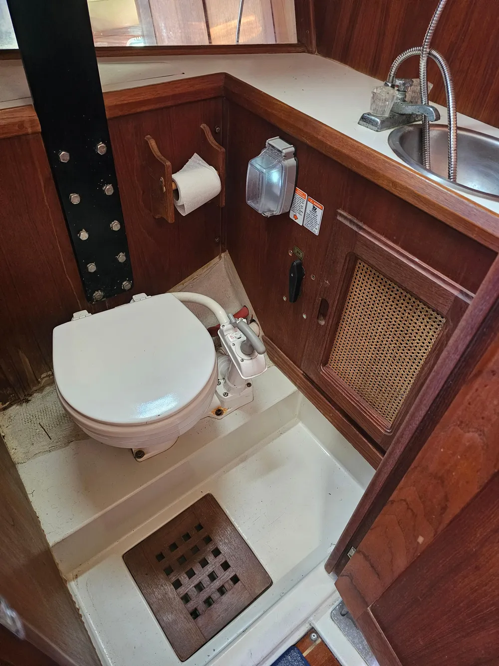 1984 Schock NY 36 boat bathroom with toilet, sink, and wooden cabinetry.