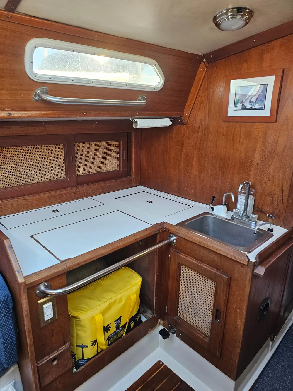 1984 Schock NY 36 yacht interior galley with wood finish, sink, and storage.