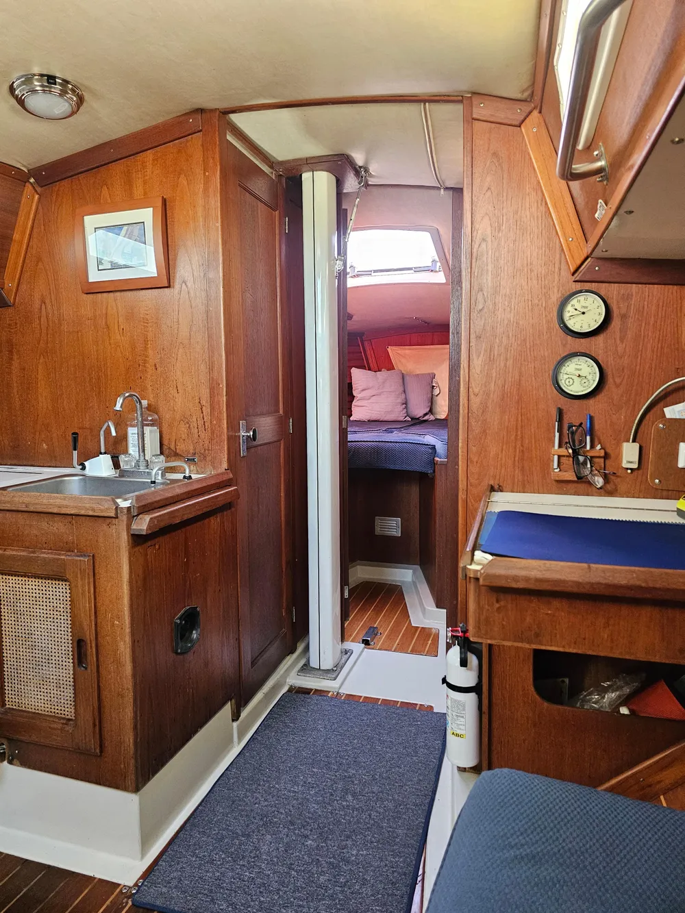 1984 Schock NY 36 yacht interior with wood finish, kitchenette, and cozy sleeping area.
