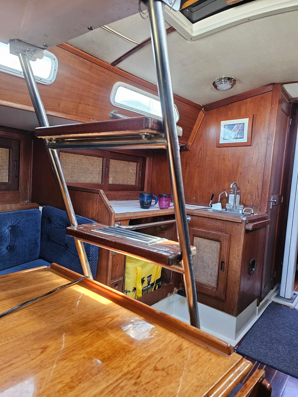 Interior of 1984 Schock NY 36 sailboat with wooden cabinetry and ladder.