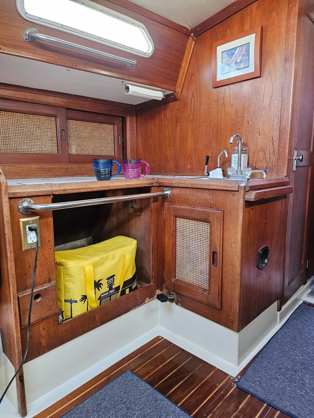 1984 Schock NY 36 yacht interior with wooden cabinetry and compact kitchen area.