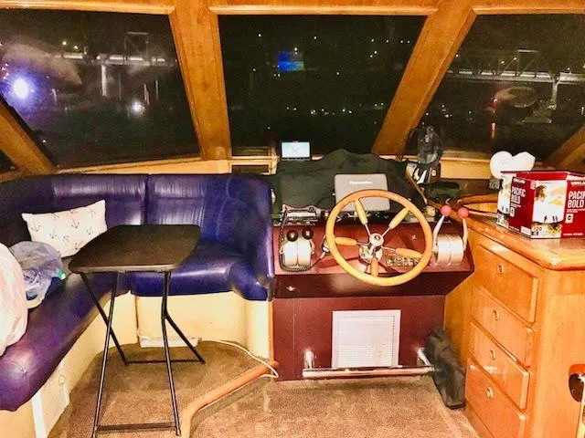 Lady Elaine Yacht Photos Pics 1993 Kha Shing Motoryacht interior with steering wheel, blue seating, and wooden cabinetry.