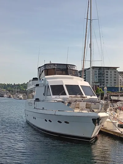 Lady Elaine Yacht Photos Pics 1993 Kha Shing Motoryacht docked in a marina, surrounded by water and buildings.