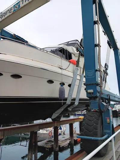 Lady Elaine Yacht Photos Pics 1993 Kha Shing Motoryacht being lifted by a boat hoist at a marina.