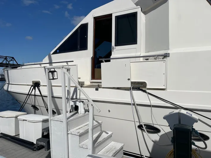 Lady Elaine Yacht Photos Pics 1993 Kha Shing Motoryacht docked, featuring white exterior and open cabin door.