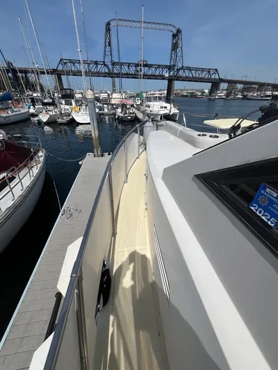 Lady Elaine Yacht Photos Pics 1993 Kha Shing Motoryacht docked at marina with bridge and sailboats in background.