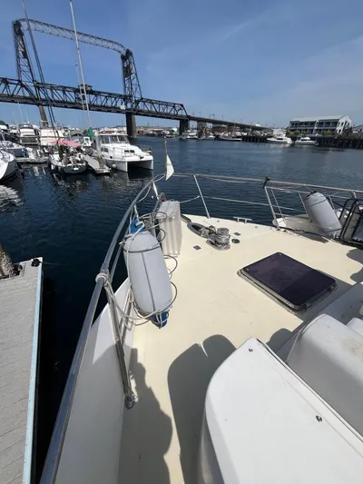 Lady Elaine Yacht Photos Pics 1993 Kha Shing Motoryacht docked near a bridge, surrounded by other boats.