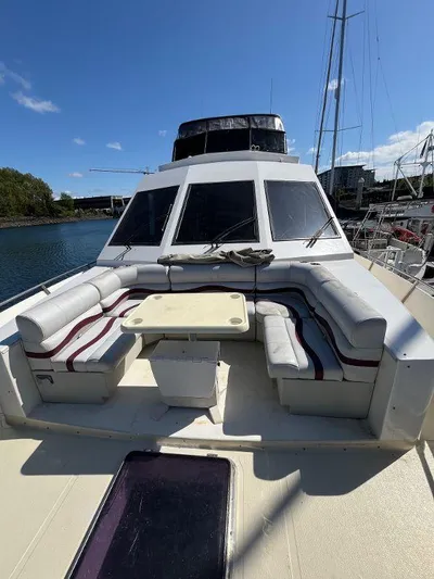 Lady Elaine Yacht Photos Pics 1993 Kha Shing Motoryacht with spacious deck seating and table, docked under clear blue skies.