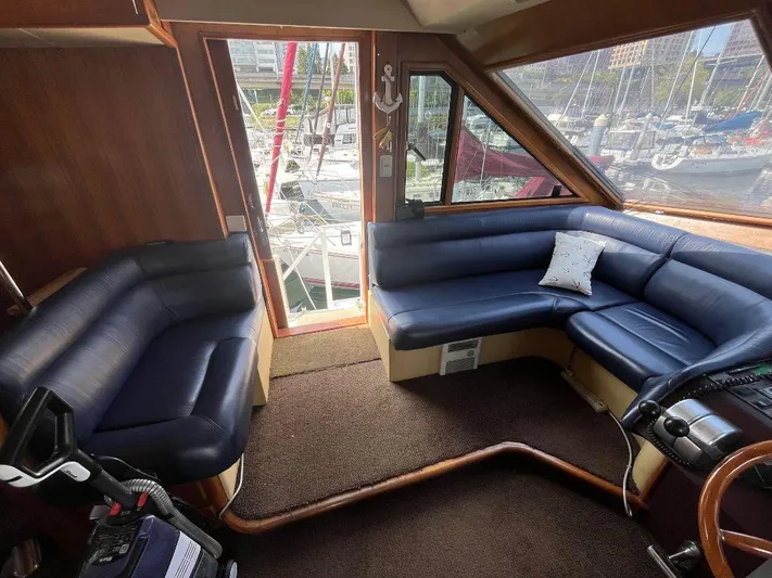 Lady Elaine Yacht Photos Pics Interior of 1993 Kha Shing Motoryacht with blue leather seating and marina view.