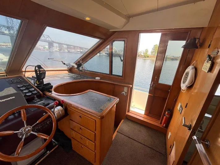 Lady Elaine Yacht Photos Pics Interior of 1993 Kha Shing Motoryacht helm with wooden steering wheel and panoramic windows.