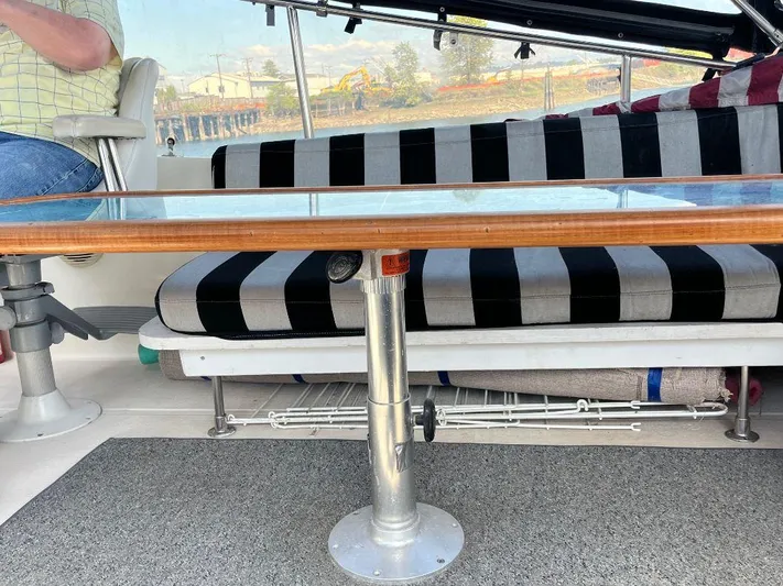 Lady Elaine Yacht Photos Pics Interior of 1993 Kha Shing Motoryacht with striped seating and wooden table.