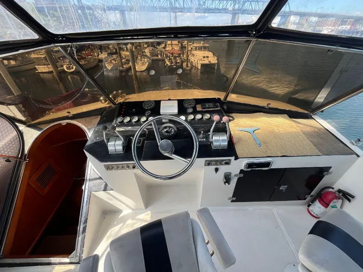 Lady Elaine Yacht Photos Pics 1993 Kha Shing Motoryacht helm with steering wheel, controls, and waterfront view.