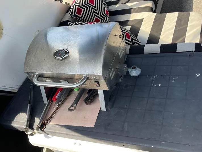 Lady Elaine Yacht Photos Pics Portable grill on a Kha Shing Motoryacht, 1993, with striped cushions and grilling tools.