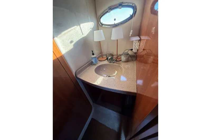 Amazing C's Yacht Photos Pics Bathroom sink area in a 2002 Regal Commodore 3860 yacht, featuring a countertop and oval window.
