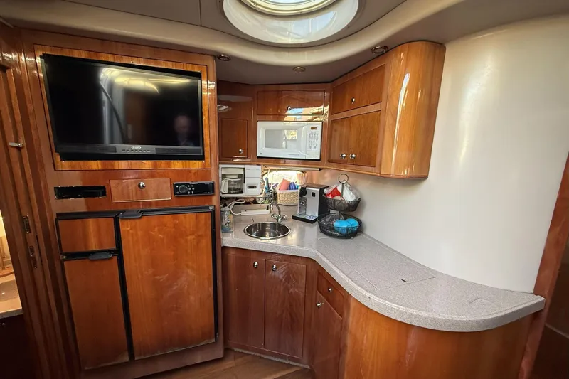 Amazing C's Yacht Photos Pics 2002 Regal Commodore 3860 yacht kitchen with wood cabinets, TV, and modern appliances.