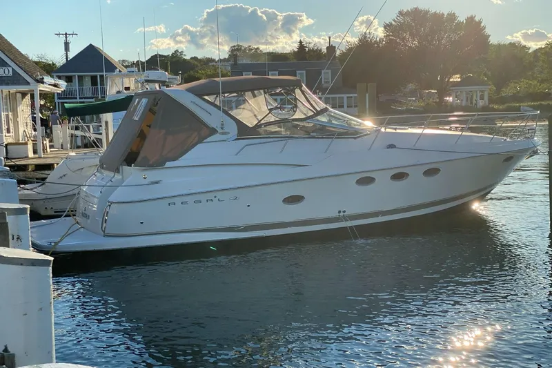 Amazing C's Yacht Photos Pics 2002 Regal Commodore 3860 yacht docked at marina, reflecting sunlight on water.