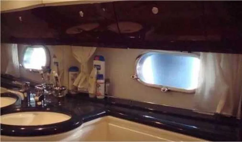  Yacht Photos Pics Luxurious bathroom interior of a 2004 Princess 65 yacht with dual sinks and porthole windows.