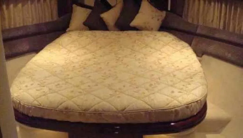  Yacht Photos Pics Luxurious bedroom interior of 2004 Princess 65 yacht with plush bedding and cushions.