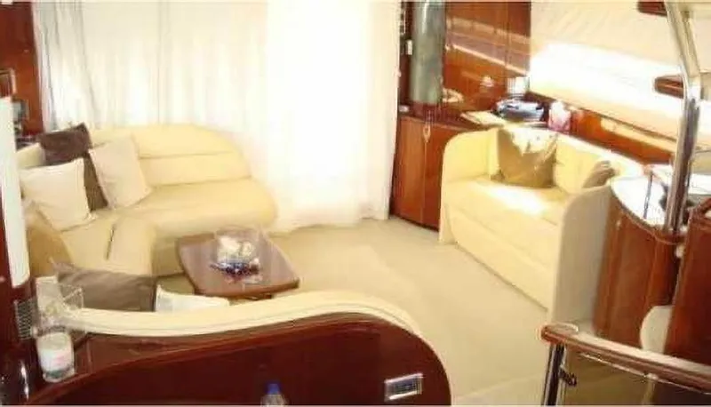  Yacht Photos Pics Luxurious interior of 2004 Princess 65 yacht with cream sofas and wooden accents.