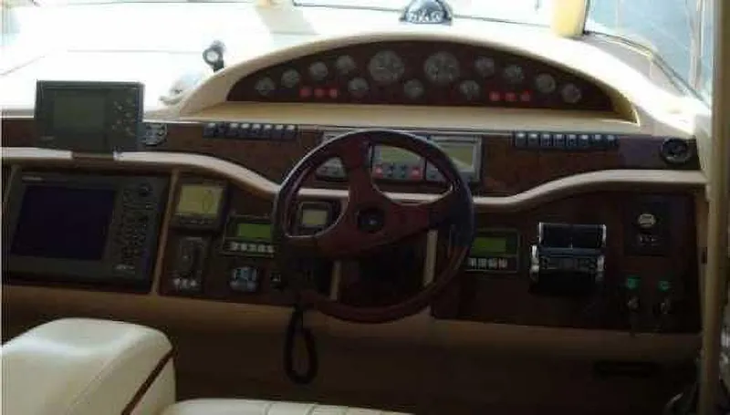 Yacht Photos Pics Control panel of a 2004 Princess 65 yacht with steering wheel and navigation instruments.